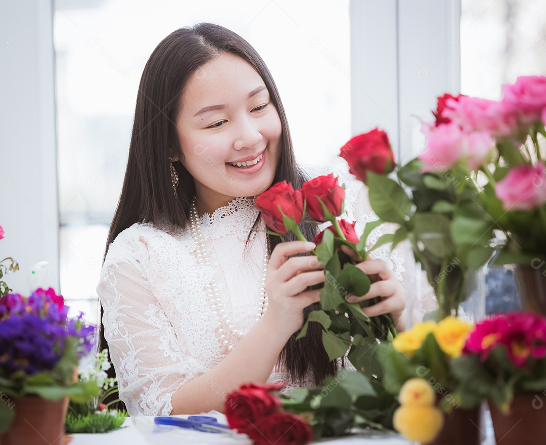Mulher se preparando para aparar rosas vermelhas e cor de rosa e lindos arranjos de flores em casa