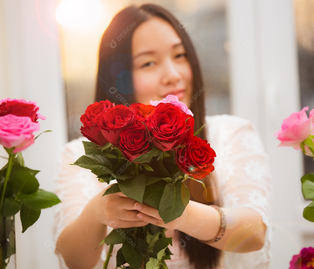 Mulher se preparando para aparar rosas vermelhas e cor de rosa e lindos arranjos de flores em casa