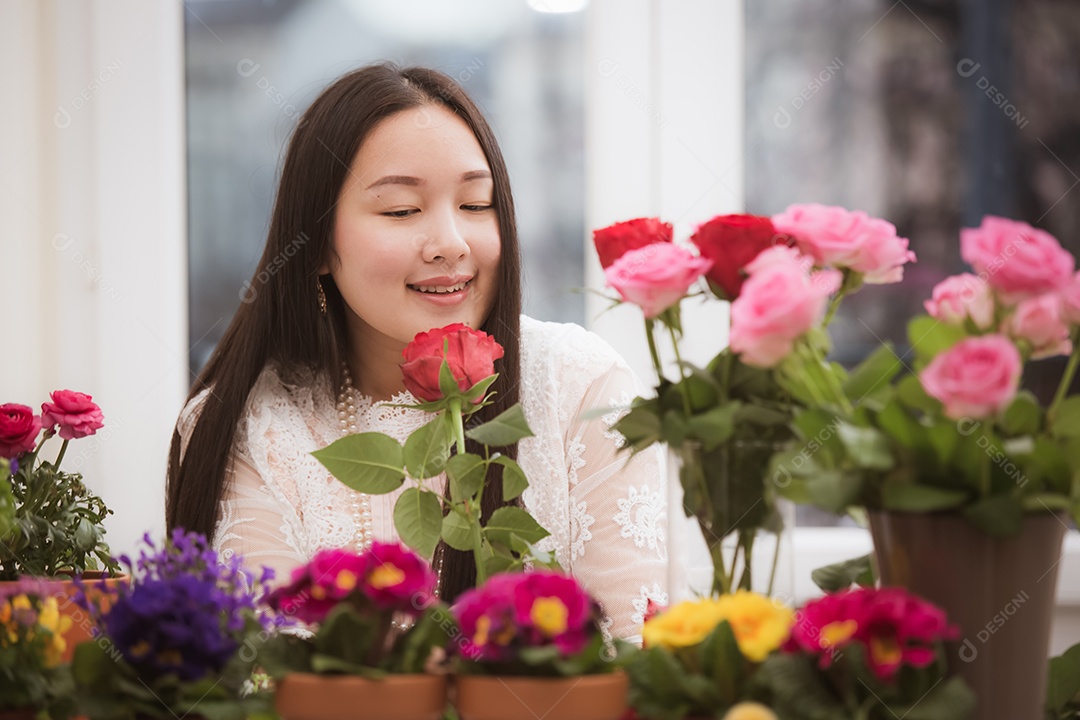 Mulher se preparando para aparar rosas vermelhas e cor de rosa e lindos arranjos de flores em casa