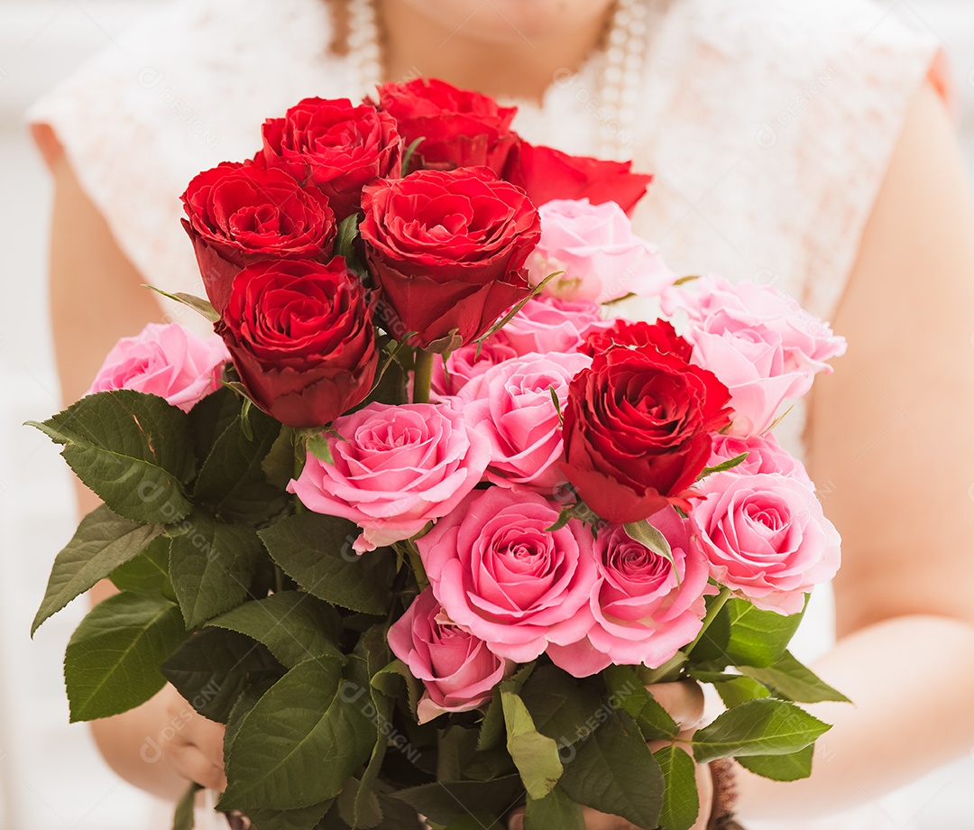 Mulher se preparando para aparar rosas vermelhas e cor de rosa e lindos arranjos de flores em casa