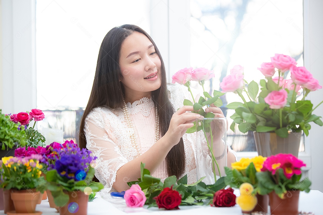 Mulher se preparando para aparar rosas vermelhas e cor de rosa e lindos arranjos de flores em casa