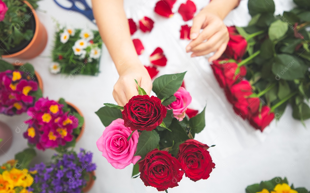 Mulher se preparando para aparar rosas vermelhas e cor de rosa e lindos arranjos de flores em casa