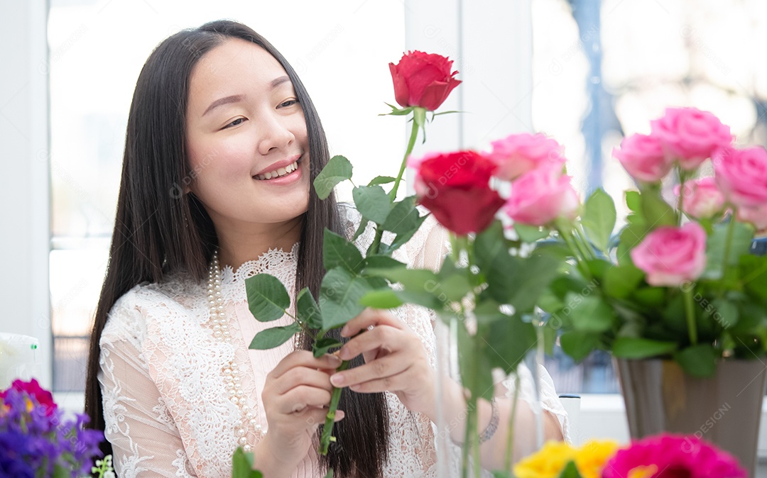 Mulher se preparando para aparar rosas vermelhas e cor de rosa e lindos arranjos de flores em casa