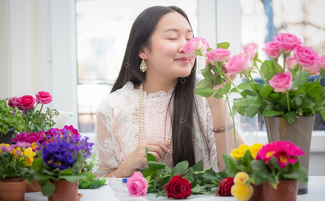 Mulher se preparando para aparar rosas vermelhas e cor de rosa e lindos arranjos de flores em casa
