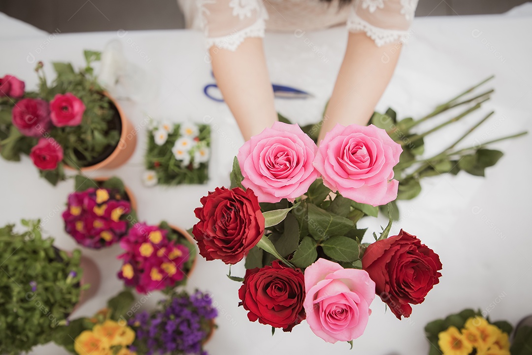 Mulher se preparando para aparar rosas vermelhas e cor de rosa e lindos arranjos de flores em casa