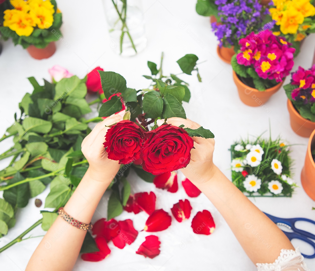 Mulher se preparando para aparar rosas vermelhas e cor de rosa e lindos arranjos de flores em casa