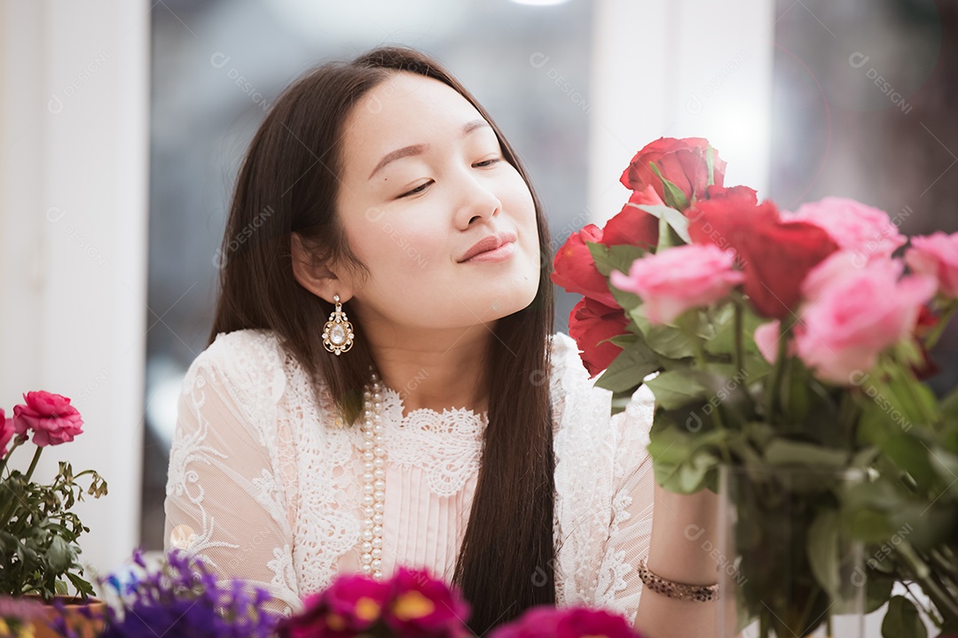 Mulher se preparando para aparar rosas vermelhas e cor de rosa e lindos arranjos de flores em casa