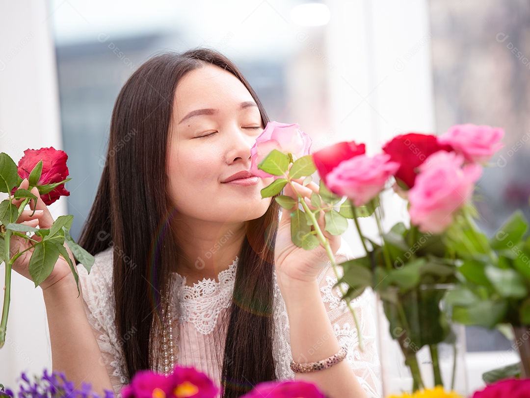 Mulher se preparando para aparar rosas vermelhas e cor de rosa e lindos arranjos de flores em casa
