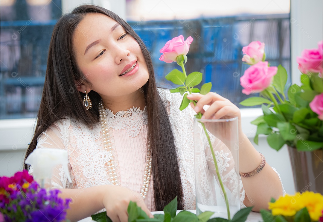 Mulher se preparando para aparar rosas vermelhas e cor de rosa e lindos arranjos de flores em casa
