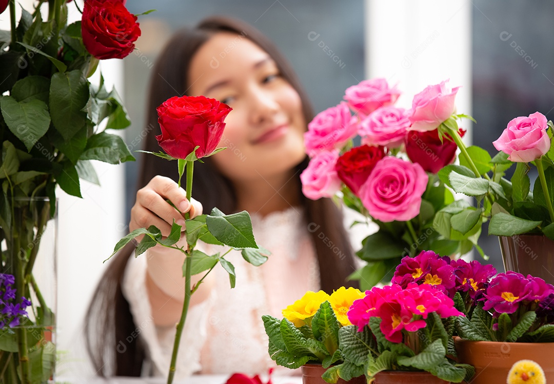 Mulher se preparando para aparar rosas vermelhas e cor de rosa e lindos arranjos de flores em casa