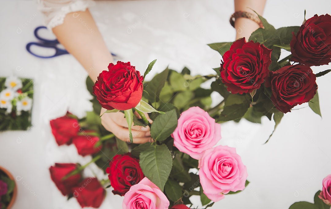 Mulher se preparando para aparar rosas vermelhas e cor de rosa e lindos arranjos de flores em casa