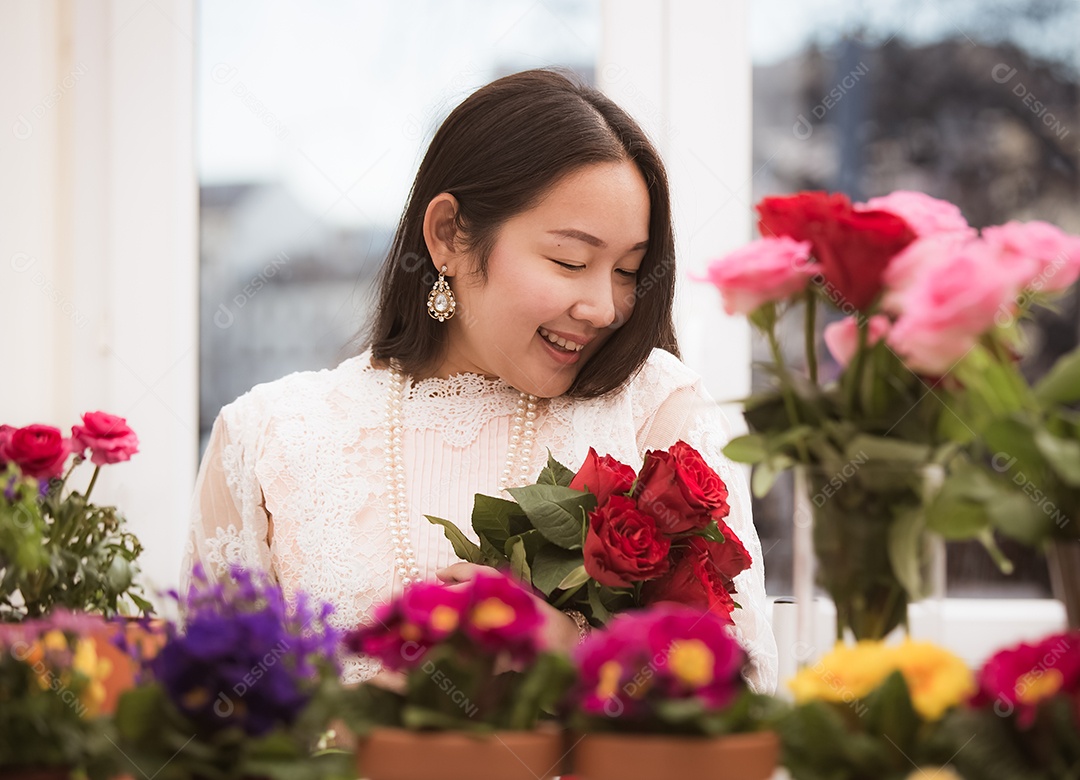Mulher se preparando para aparar rosas vermelhas e cor de rosa e lindos arranjos de flores em casa
