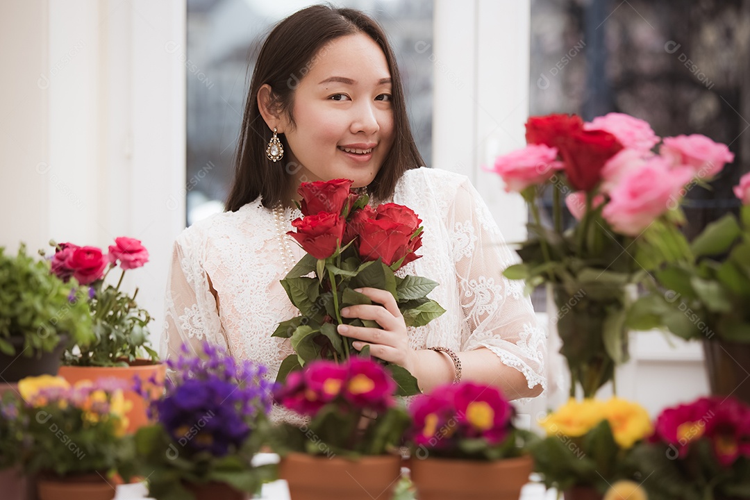 Mulher se preparando para aparar rosas vermelhas e cor de rosa e lindos arranjos de flores em casa