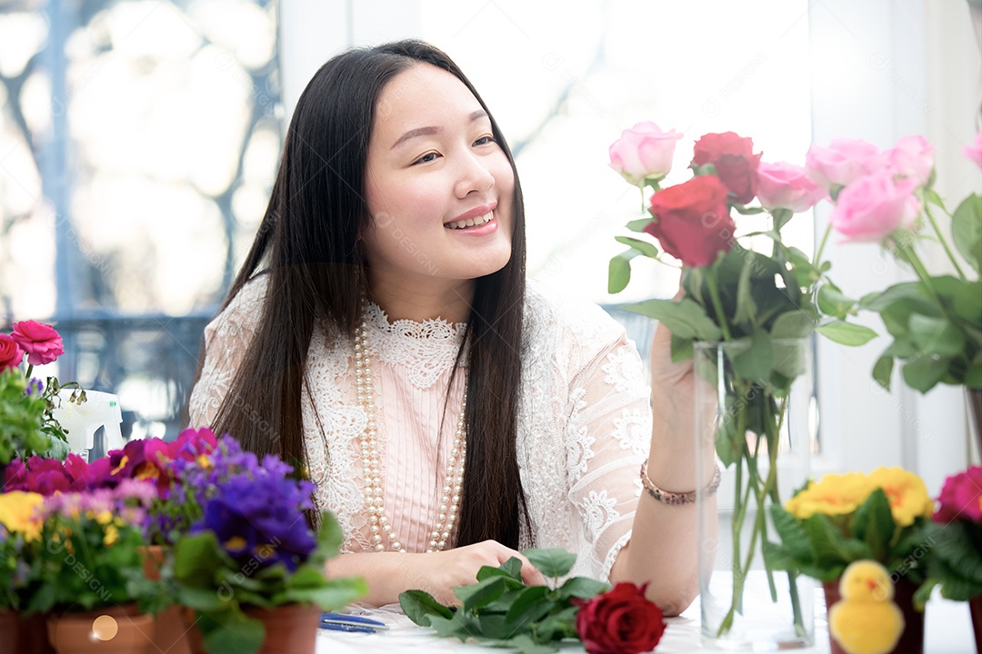 Mulher se preparando para aparar rosas vermelhas e cor de rosa e lindos arranjos de flores em casa