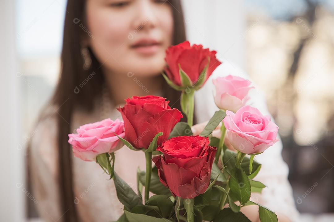 Mulher se preparando para aparar rosas vermelhas e cor de rosa e lindos arranjos de flores em casa