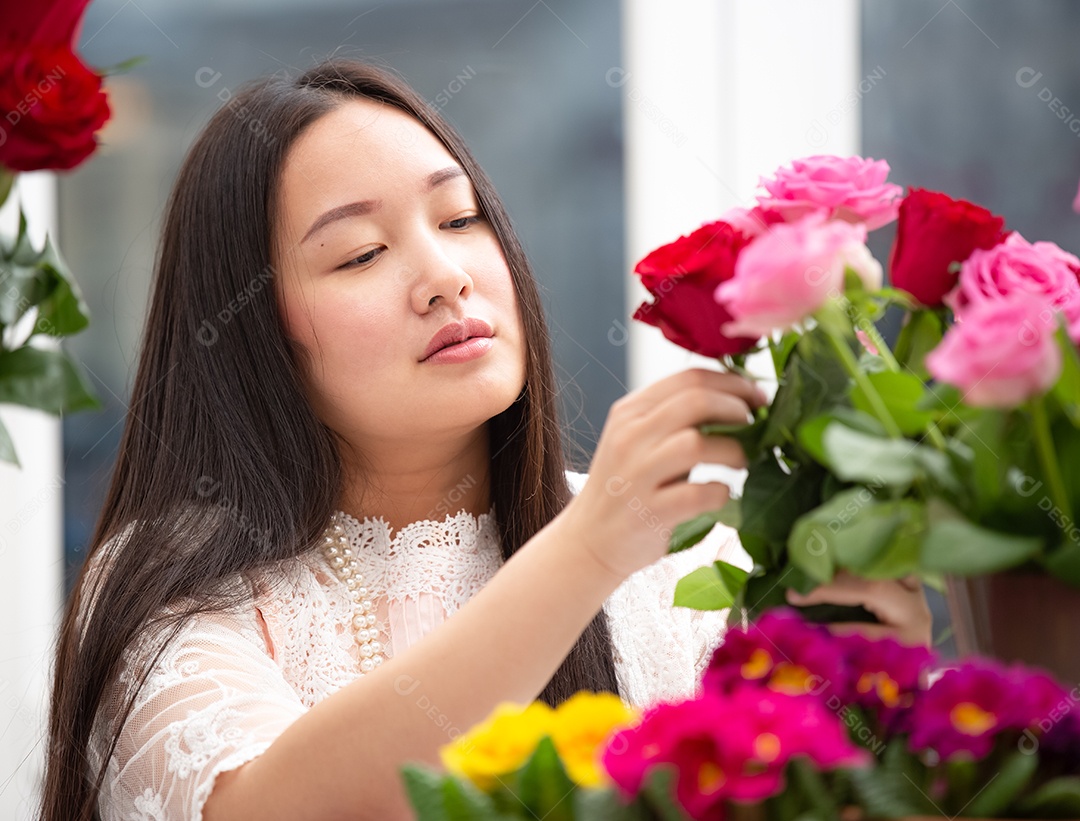 Mulher se preparando para aparar rosas vermelhas e cor de rosa e lindos arranjos de flores em casa