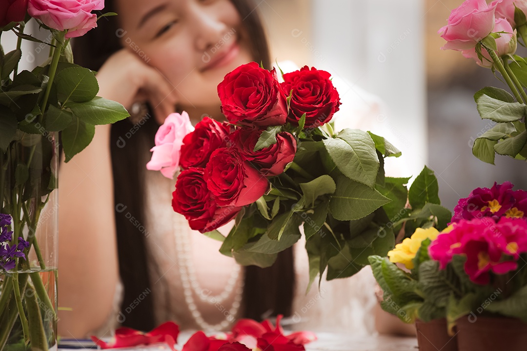 Mulher se preparando para aparar rosas vermelhas e cor de rosa e lindos arranjos de flores em casa