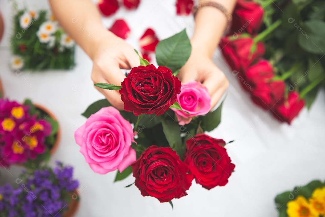 Mulher se preparando para aparar rosas vermelhas e cor de rosa e lindos arranjos de flores em casa