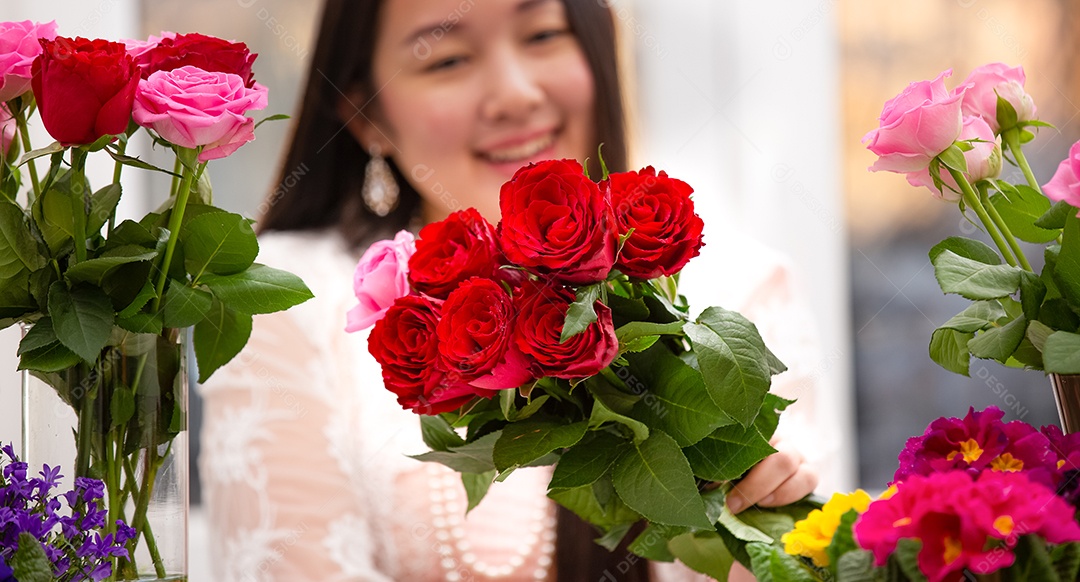 Mulher se preparando para aparar rosas vermelhas e cor de rosa e lindos arranjos de flores em casa