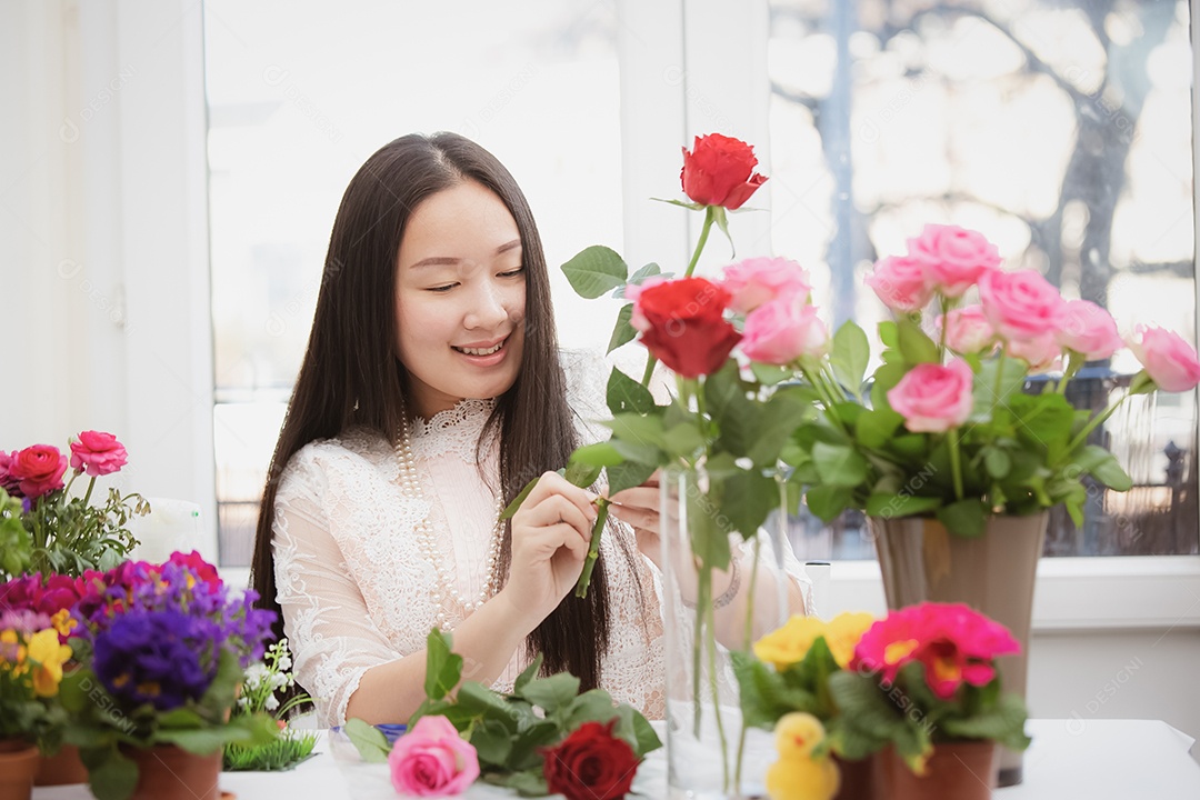 Mulher se preparando para aparar rosas vermelhas e cor de rosa e lindos arranjos de flores em casa