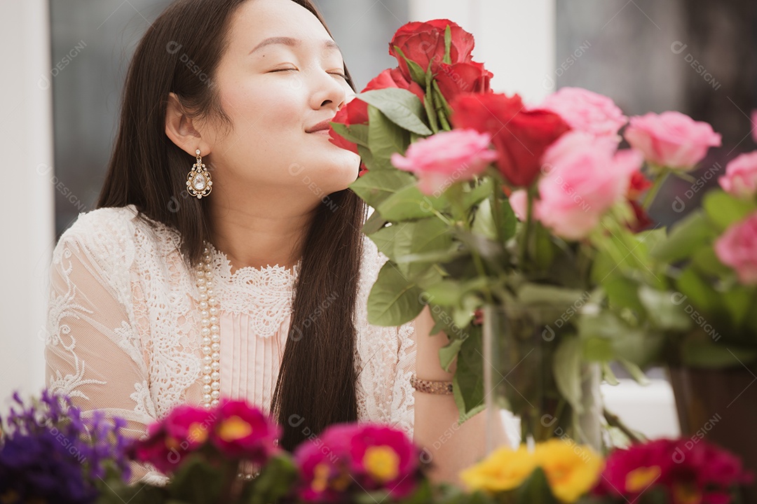 Mulher se preparando para aparar rosas vermelhas e cor de rosa e lindos arranjos de flores em casa