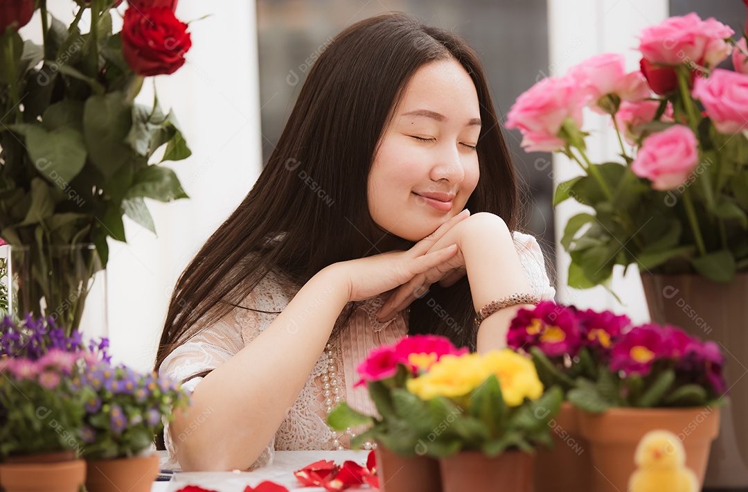 Mulher se preparando para aparar rosas vermelhas e cor de rosa e lindos arranjos de flores em casa