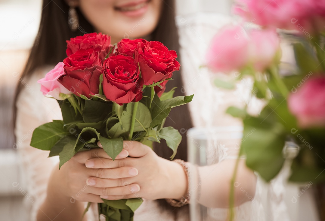 Mulher se preparando para aparar rosas vermelhas e cor de rosa e lindos arranjos de flores em casa