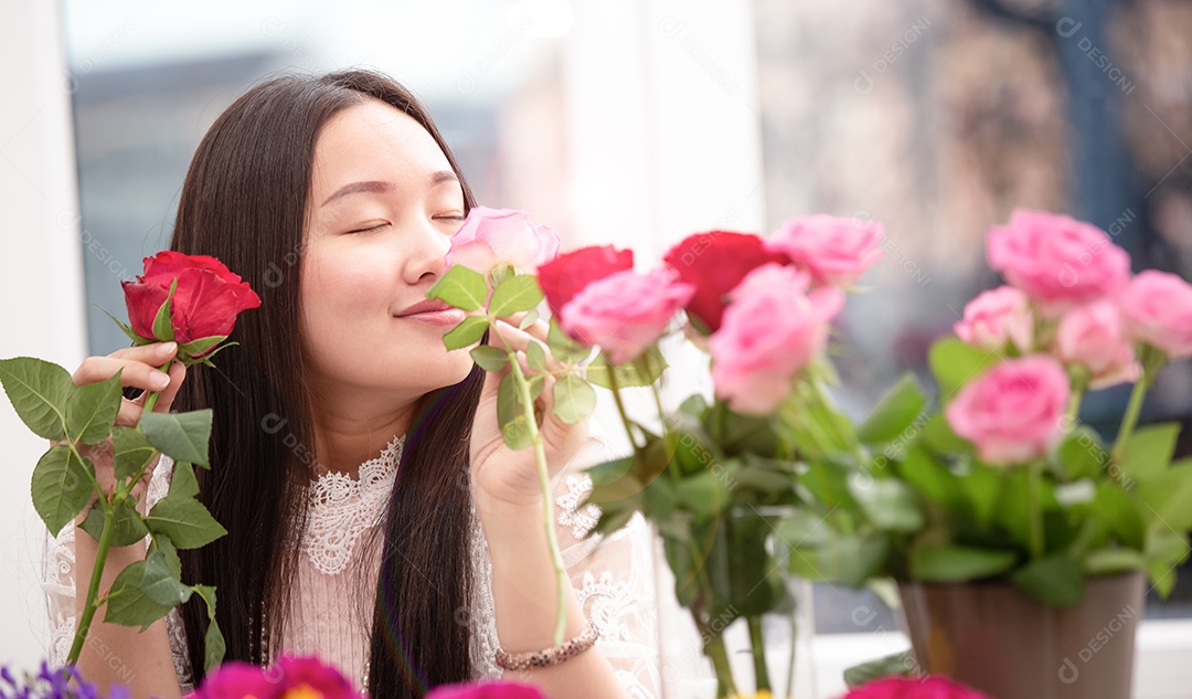 Mulher se preparando para aparar rosas vermelhas e cor de rosa e lindos arranjos de flores em casa