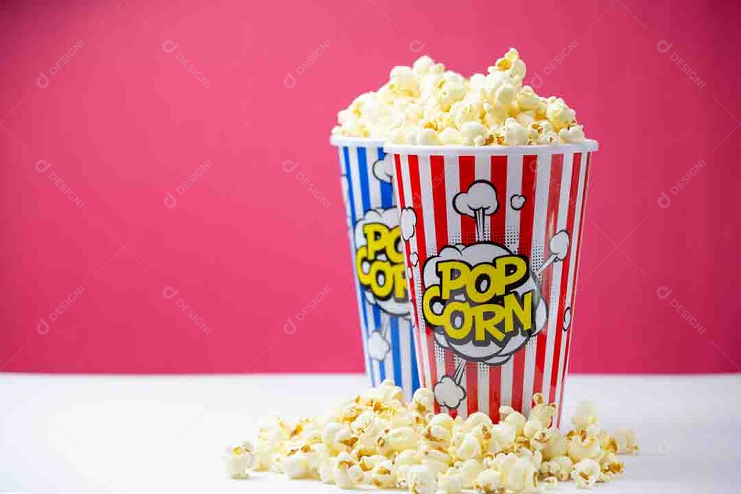 Pipoca de manteiga assada em um copo de papel listrado azul