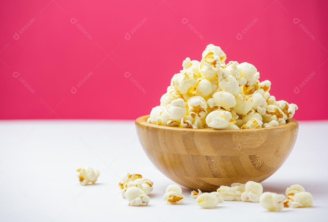 Pipoca de manteiga assada na tigela grande de madeira sobre a mesa de madeira