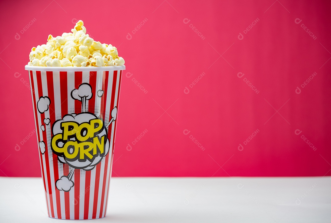 Pipoca de manteiga assada em um copo de papel listrado