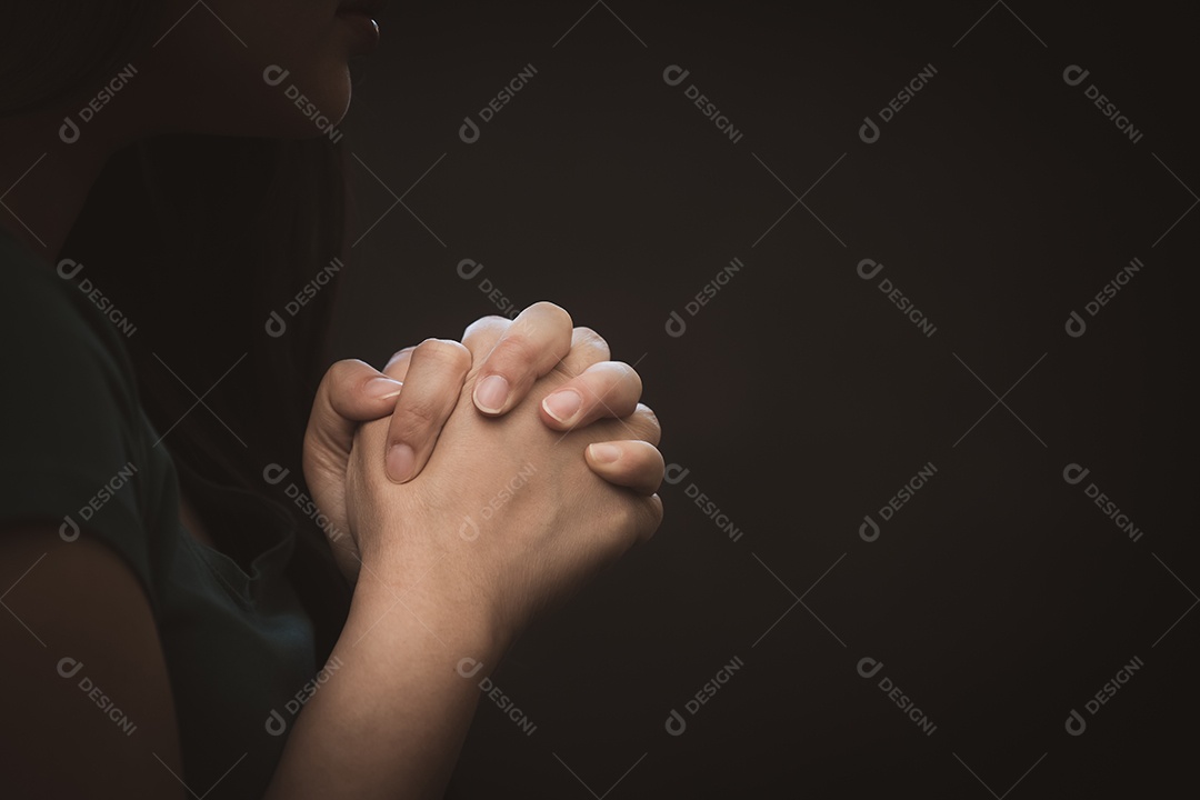 Mão de mulher rezando e adorando a Deus usando as mãos para orar em crenças religiosas e adoração cristã em fundo preto e branco