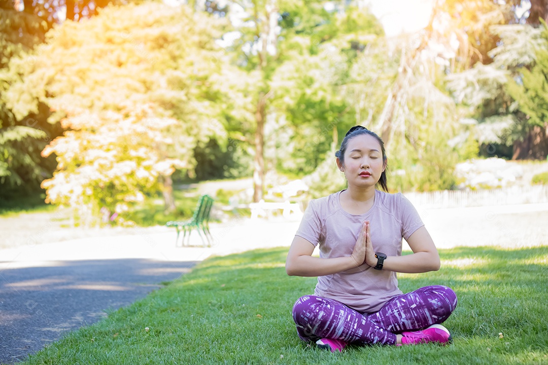 Jovem asiática fazendo exercícios de ioga no parque natural