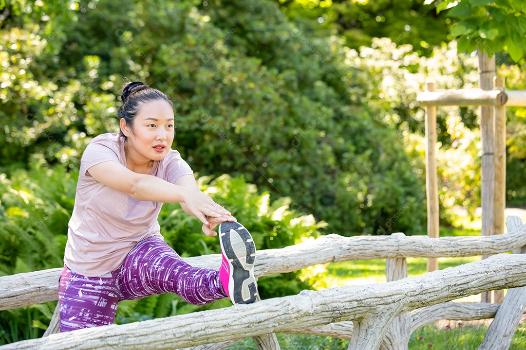 Jovem asiática fazendo exercícios de corrida no parque natural
