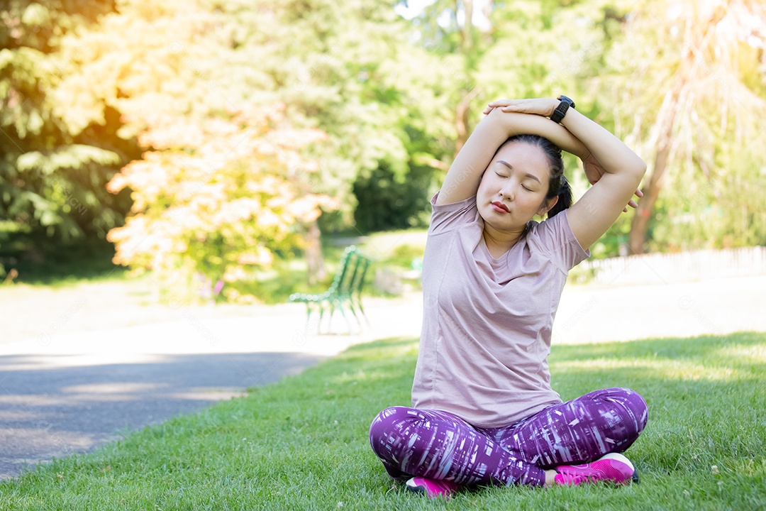 jovem asiática fazendo exercícios de ioga no parque natural