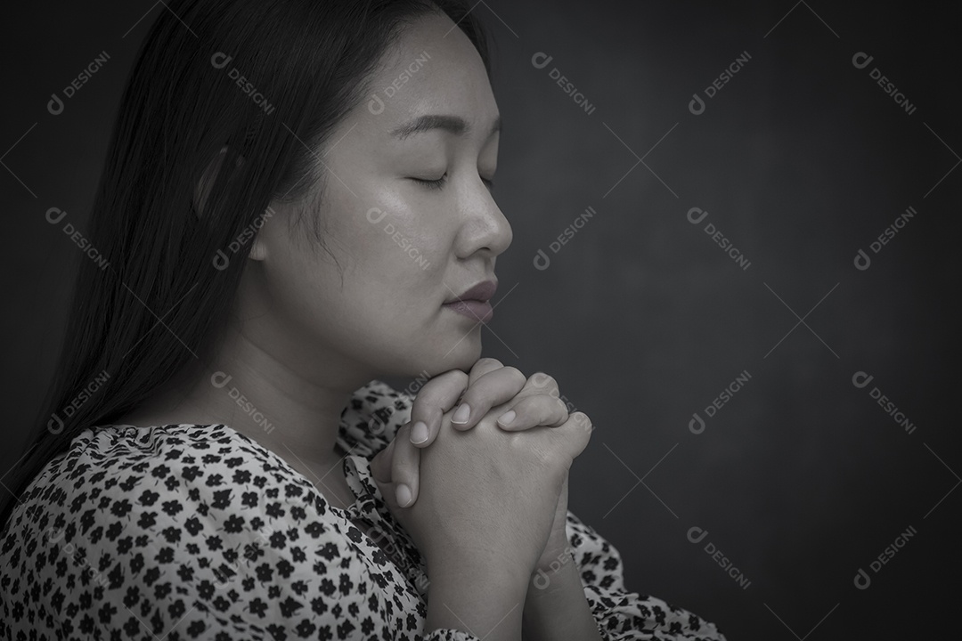 Mulher de rosto asiático orando e adorando a DEUS usando as mãos para orar em crenças religiosas e adorar