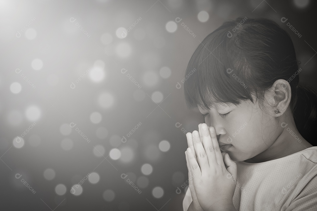 Rosto asiático Criança orando e adorando a Deus usando as mãos para orar em crenças religiosas e adoração cristã na igreja ou em locais gerais em fundo branco e preto