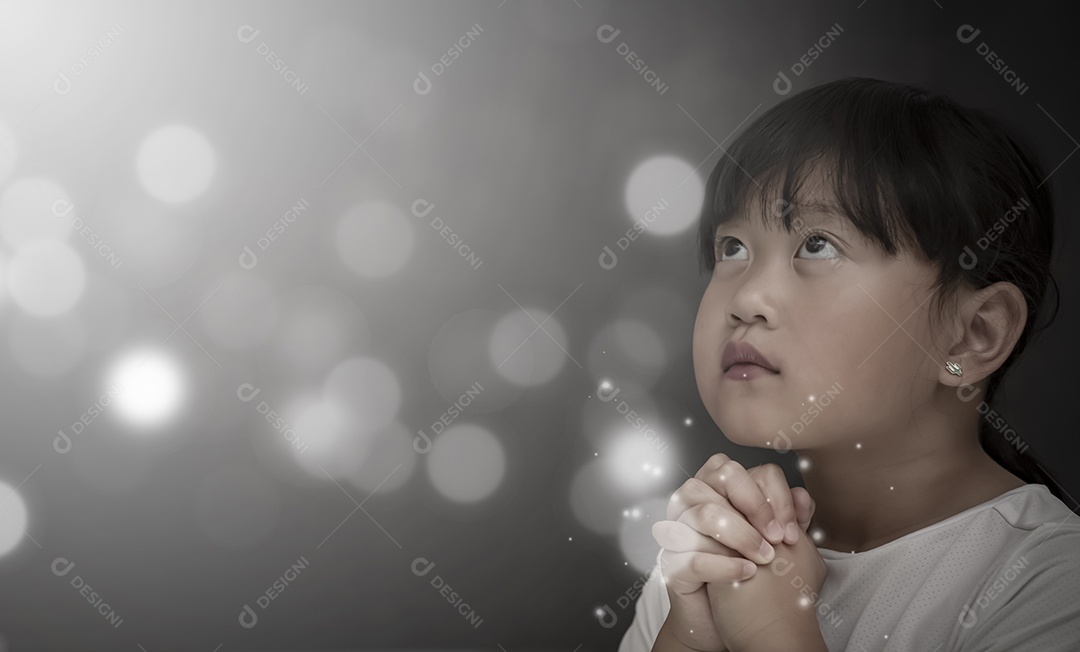 Rosto asiático Criança orando e adorando a Deus usando as mãos para orar em crenças religiosas e adoração cristã na igreja ou em locais gerais em fundo branco e preto