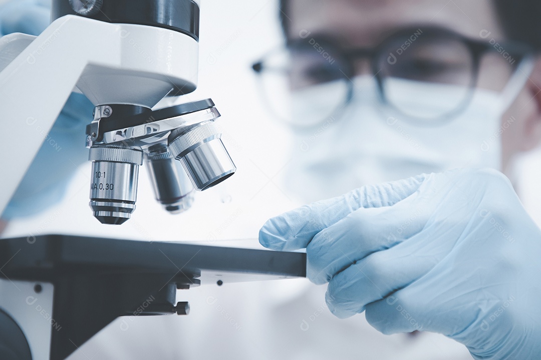 Cientista de pesquisa bioquímica trabalhando com microscópio para coronavírus