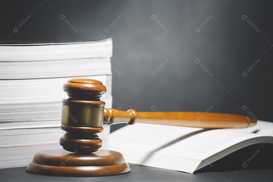 Martelo de juiz de madeira antigo com livro de leis sobre a mesa de fundo de madeira