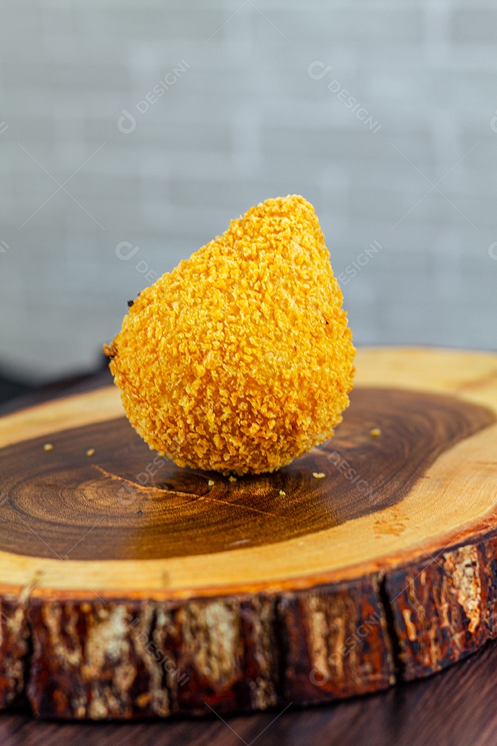 Imagem de coxinhas sobre taboa de madeira.