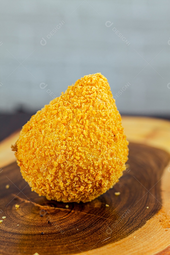 Imagem de coxinhas sobre taboa de madeira.