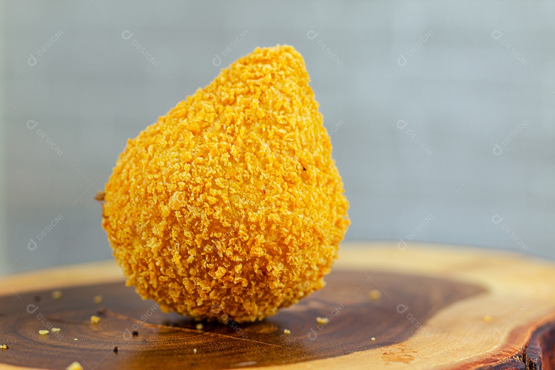 Imagem de coxinhas sobre taboa de madeira.