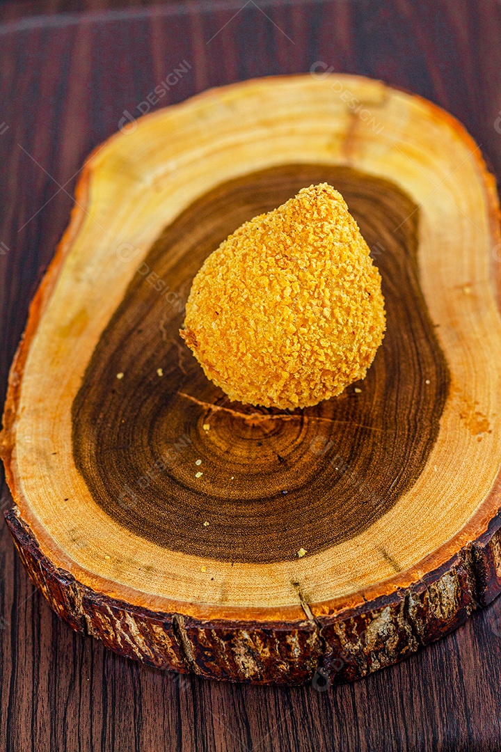Imagem de coxinhas sobre taboa de madeira.