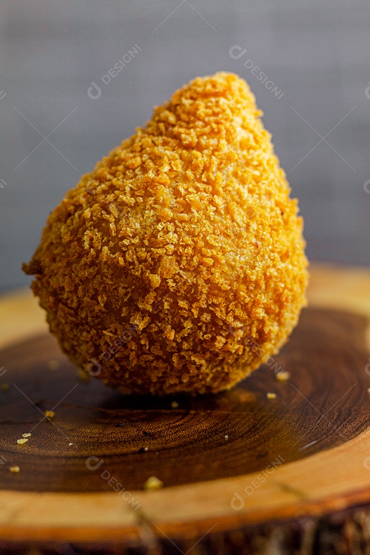 Imagem de coxinhas sobre taboa de madeira.