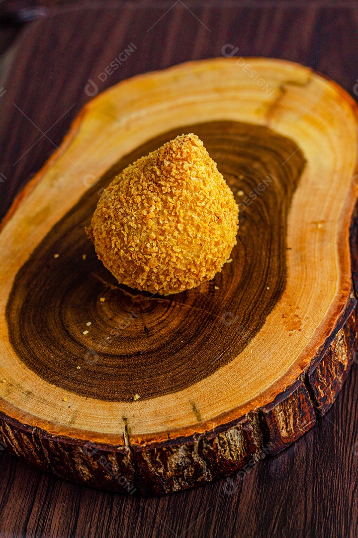 Imagem de coxinhas sobre taboa de madeira.