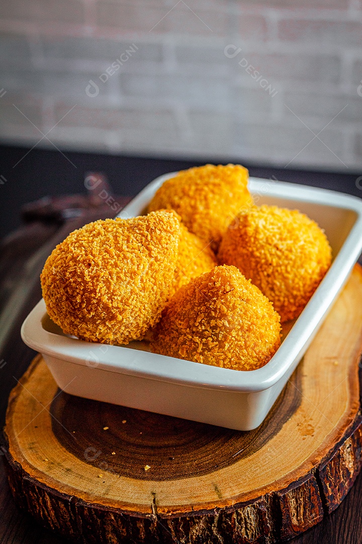 Imagem de coxinhas sobre taboa de madeira.