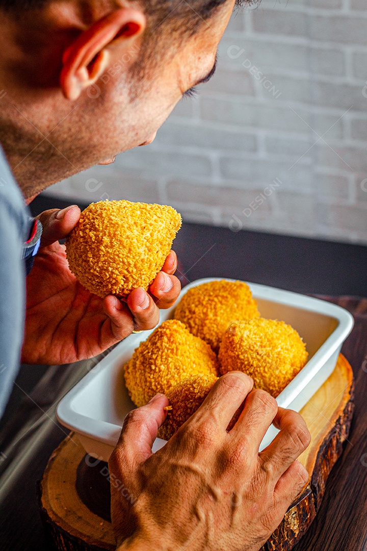 Imagem de homem comendo coxinha.