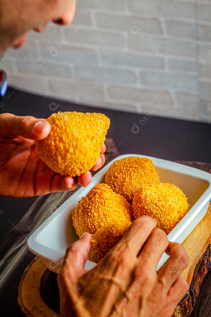 Imagem de homem comendo coxinha.