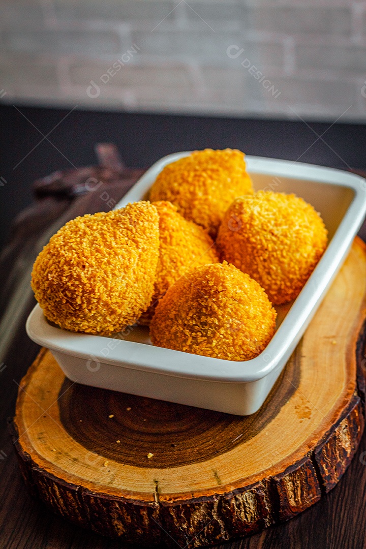 Imagem de coxinha sobre taboa de madeira.